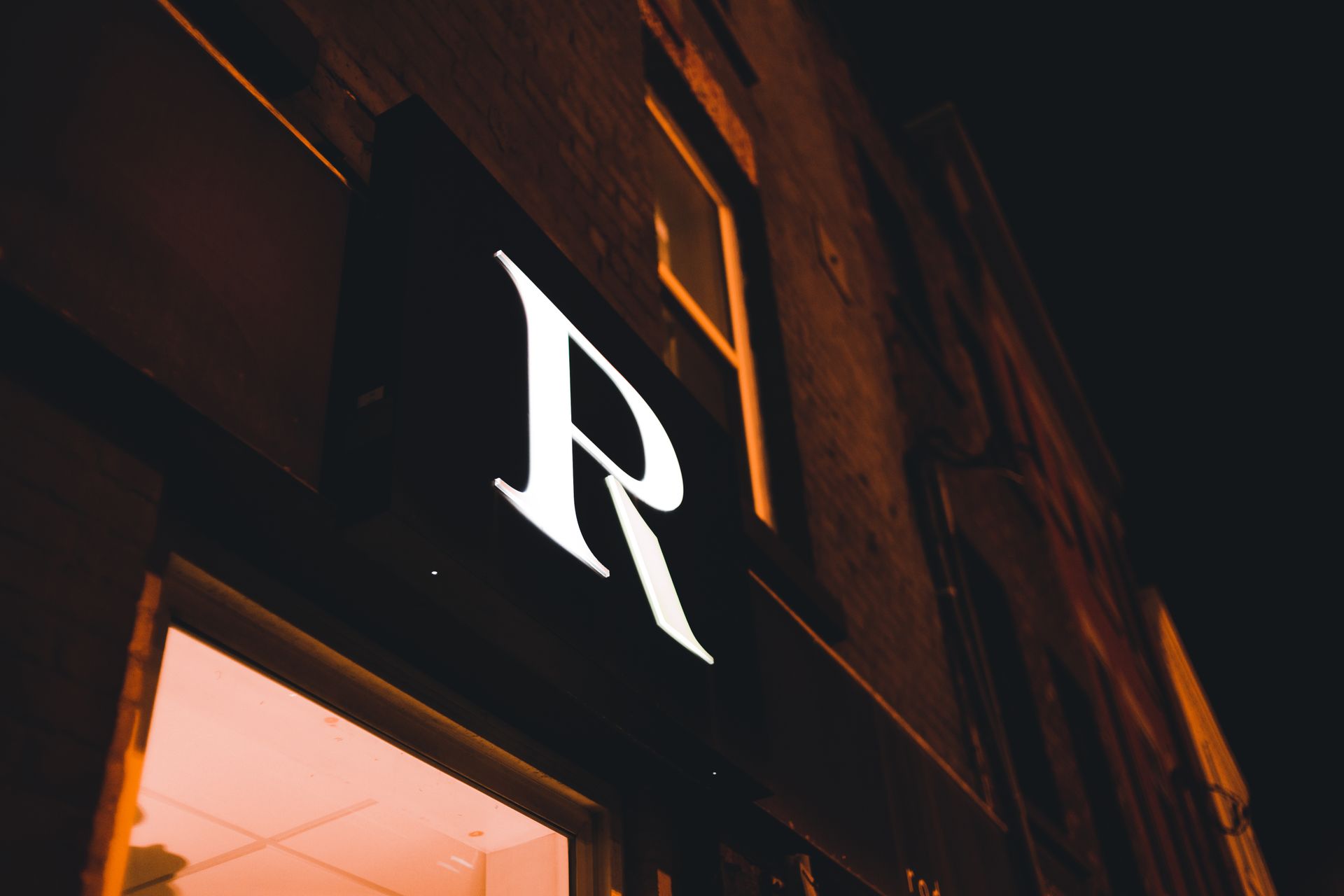Illuminated storefront letter sign at night