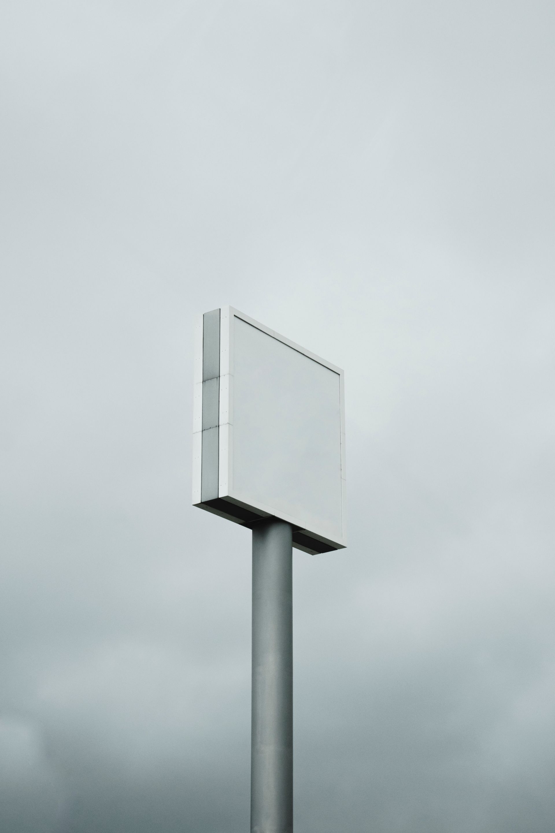 Tall roadside sign structure against an overcast sky