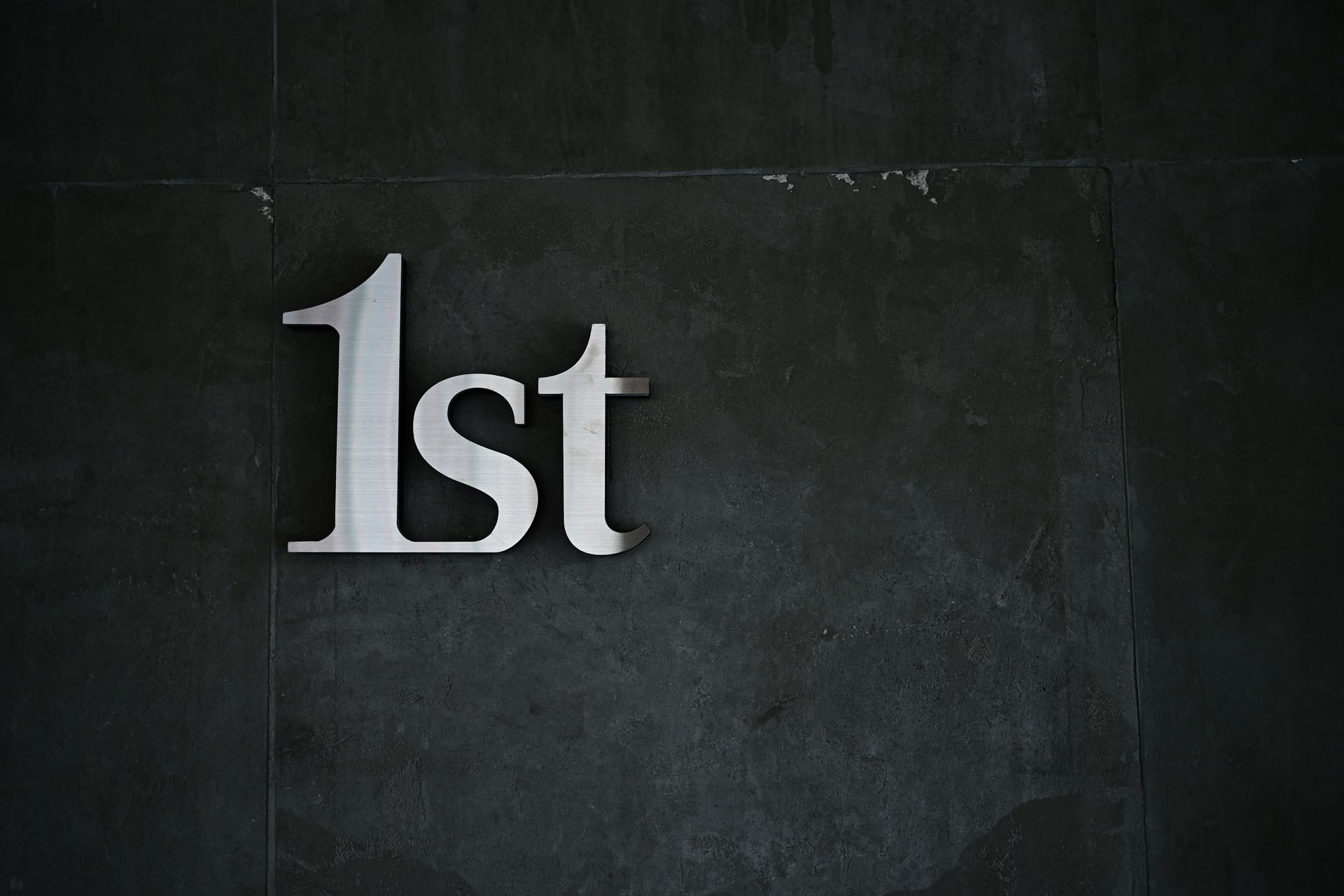 Metal letters mounted on a dark wall