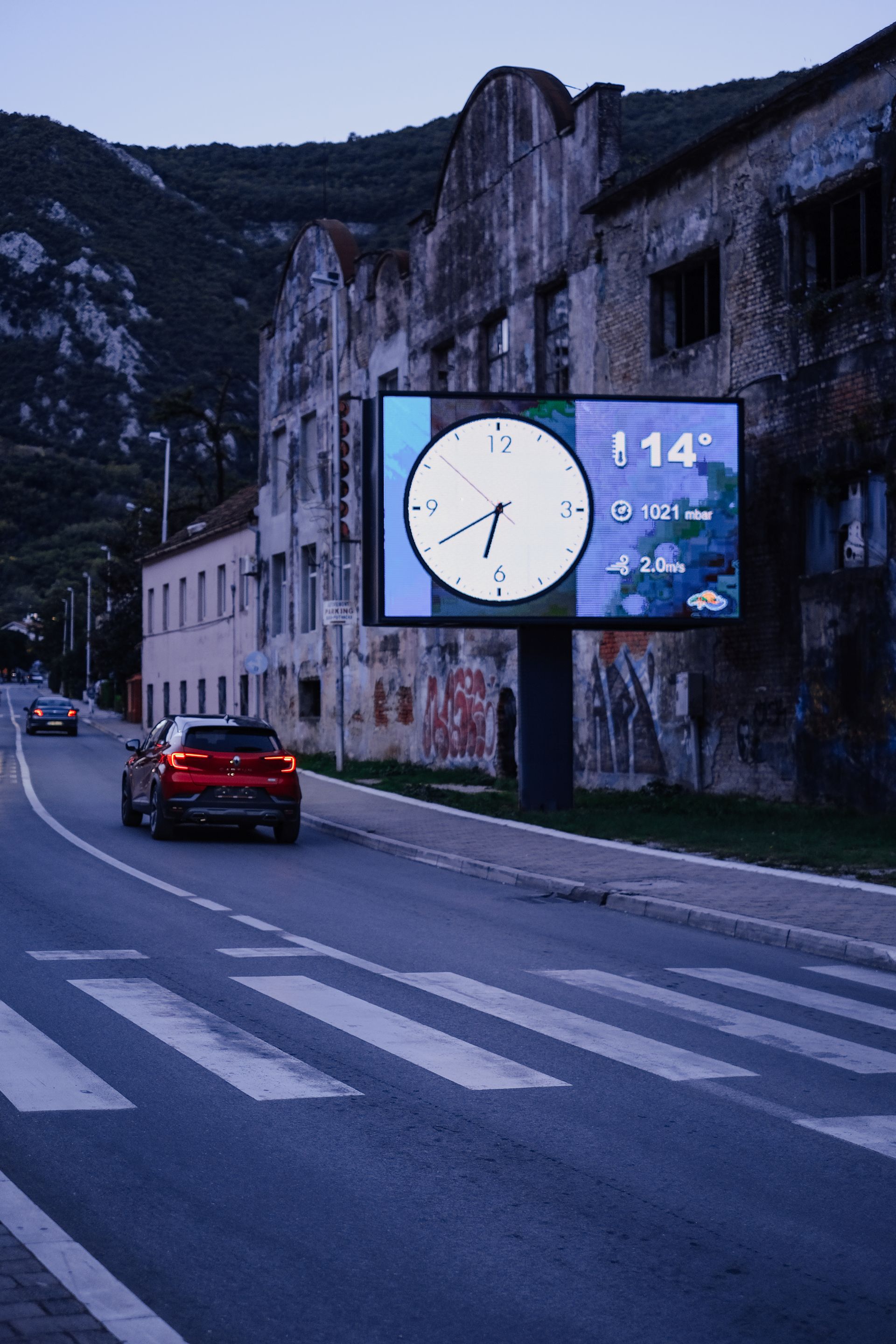 Lit digital display on a city street in the evening