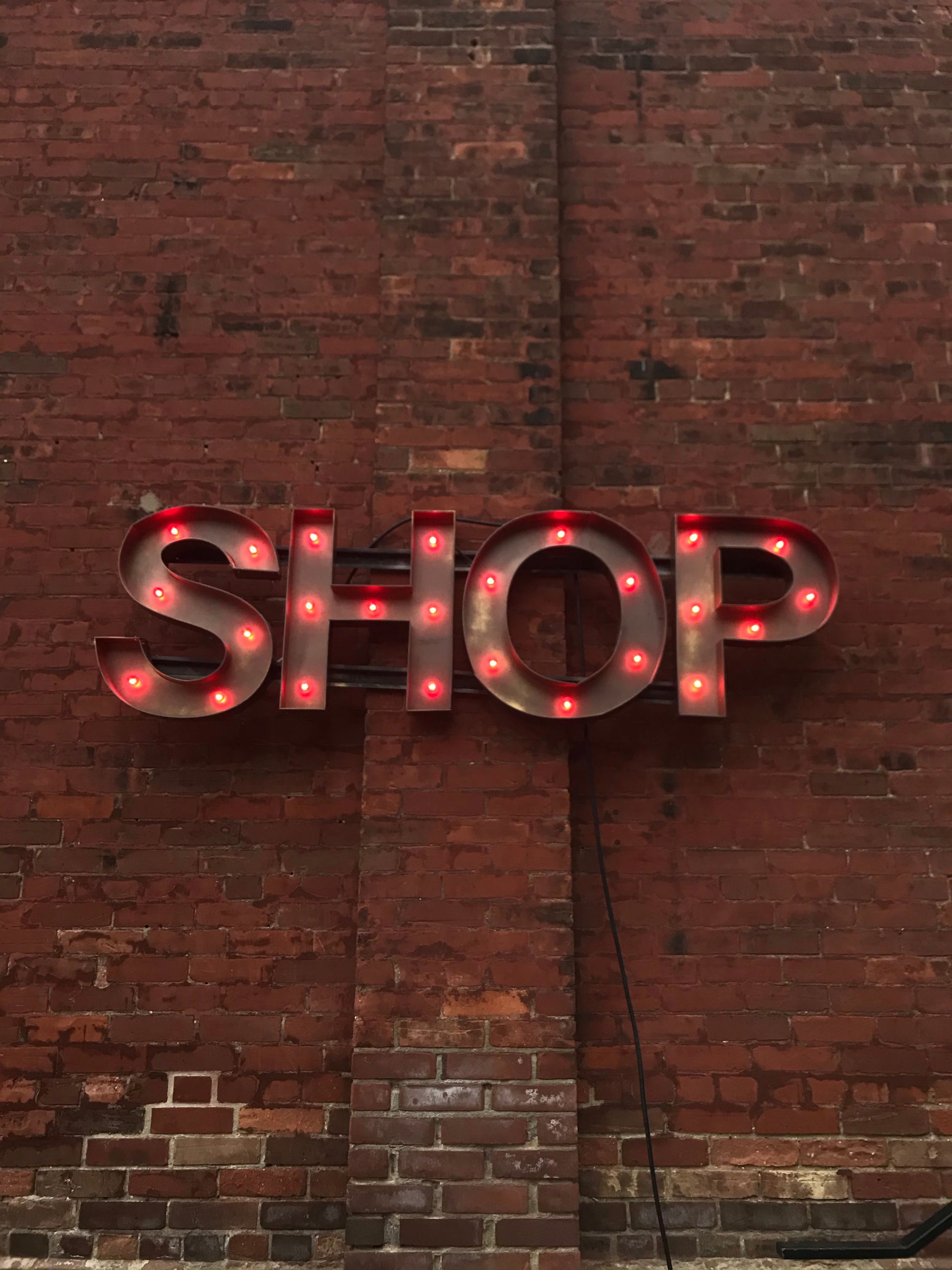 Metal shop sign on a brick wall