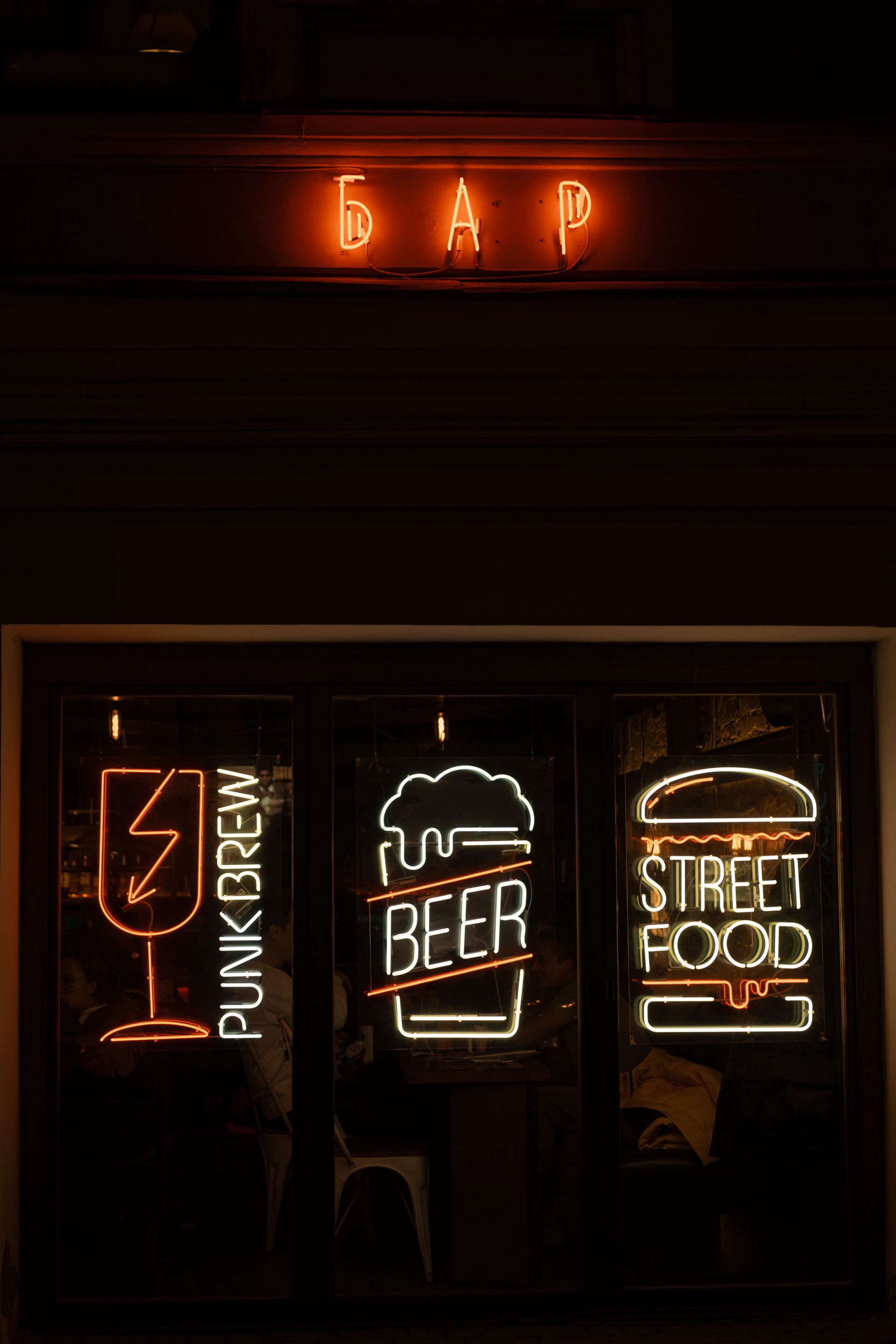 Glowing projecting signs outside a pub at night