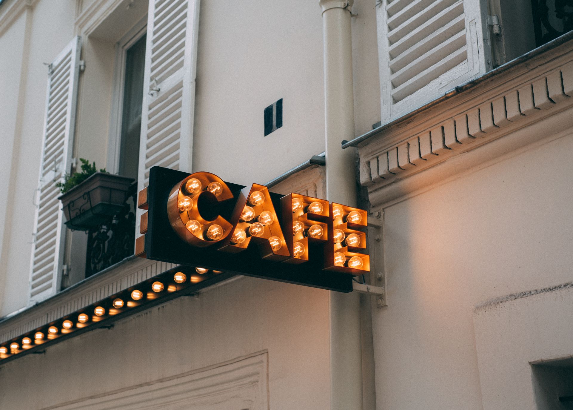 Café sign framed with glowing bulbs