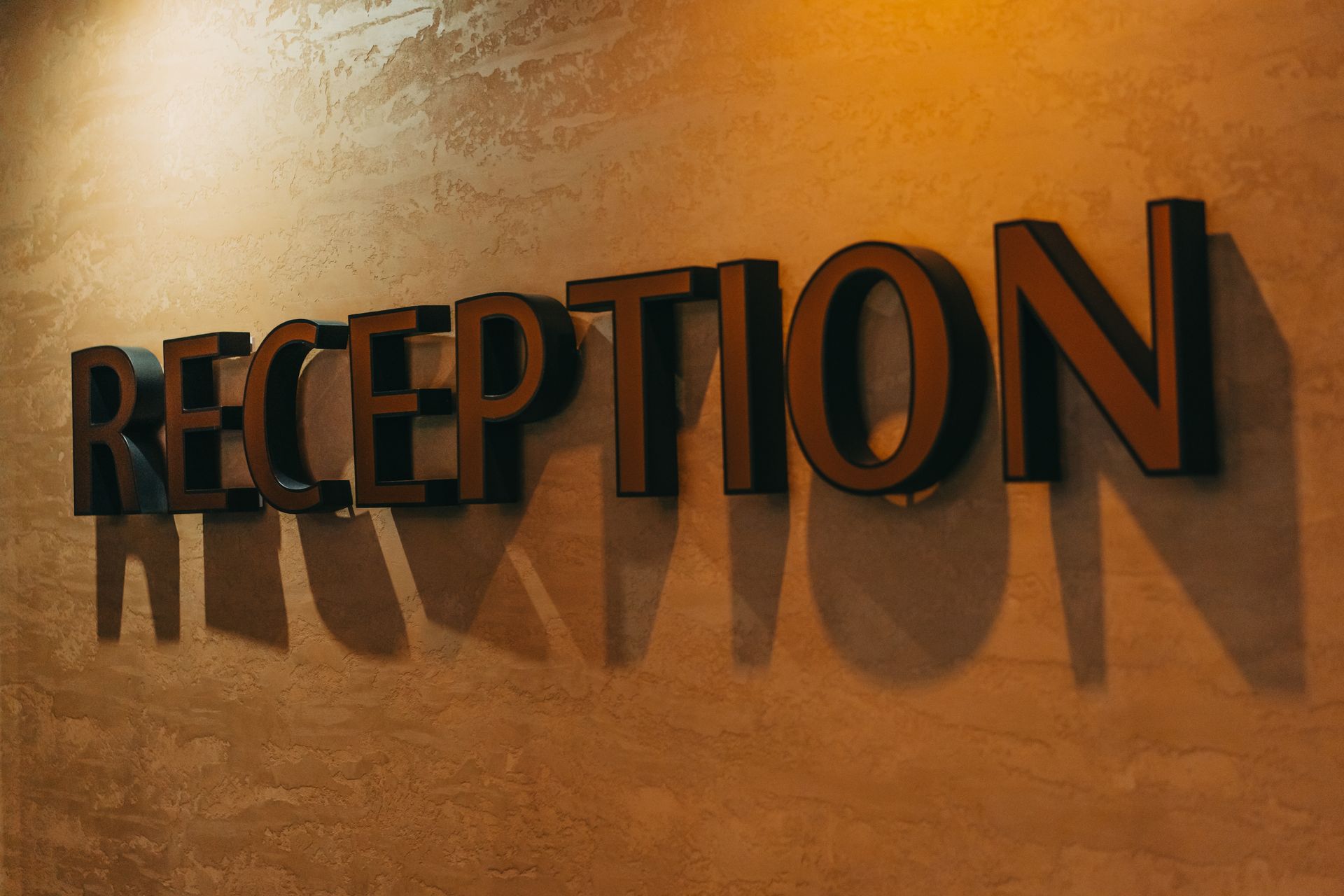 Reception sign casting shadows on a textured wall