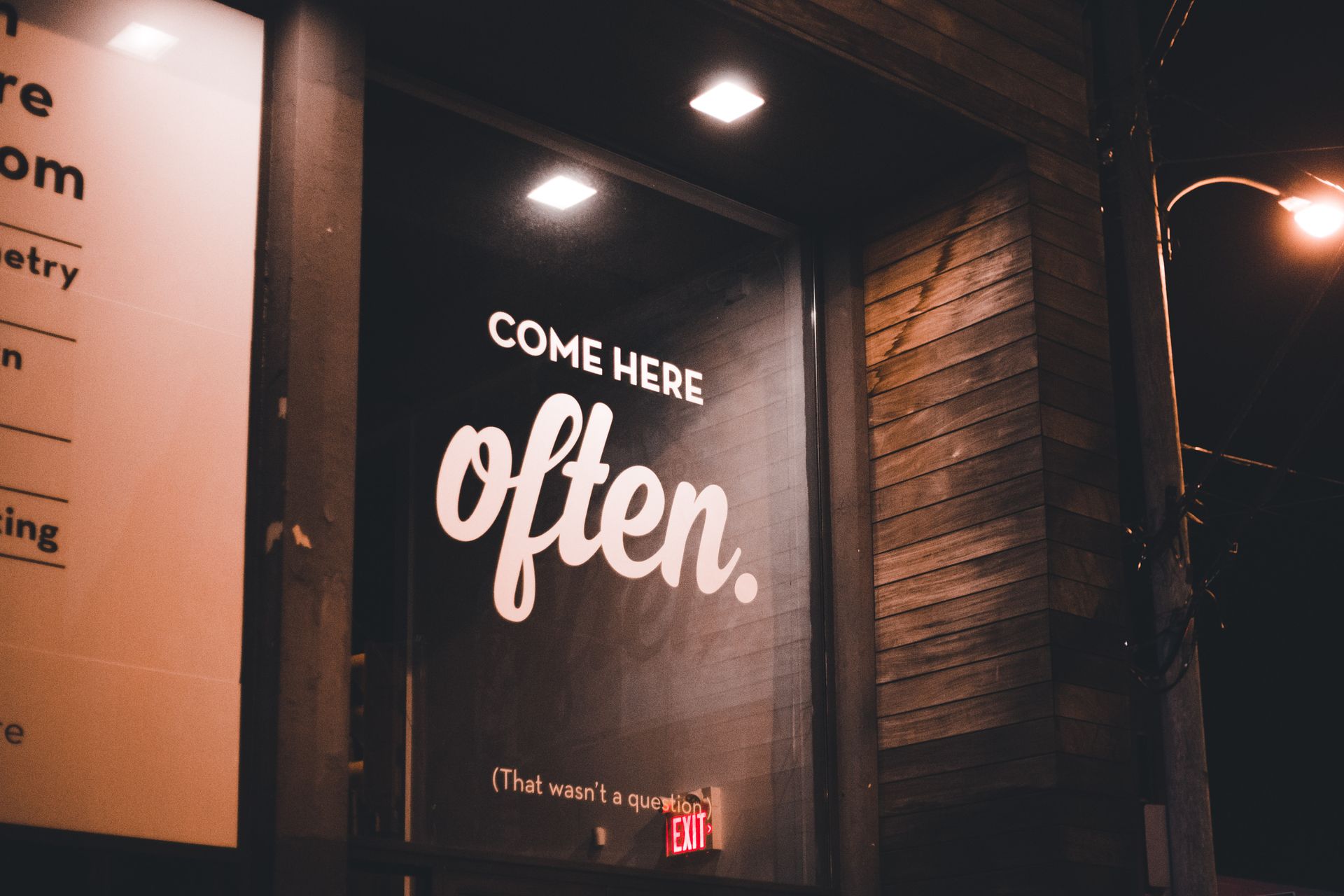 Storefront at night with a lit sign