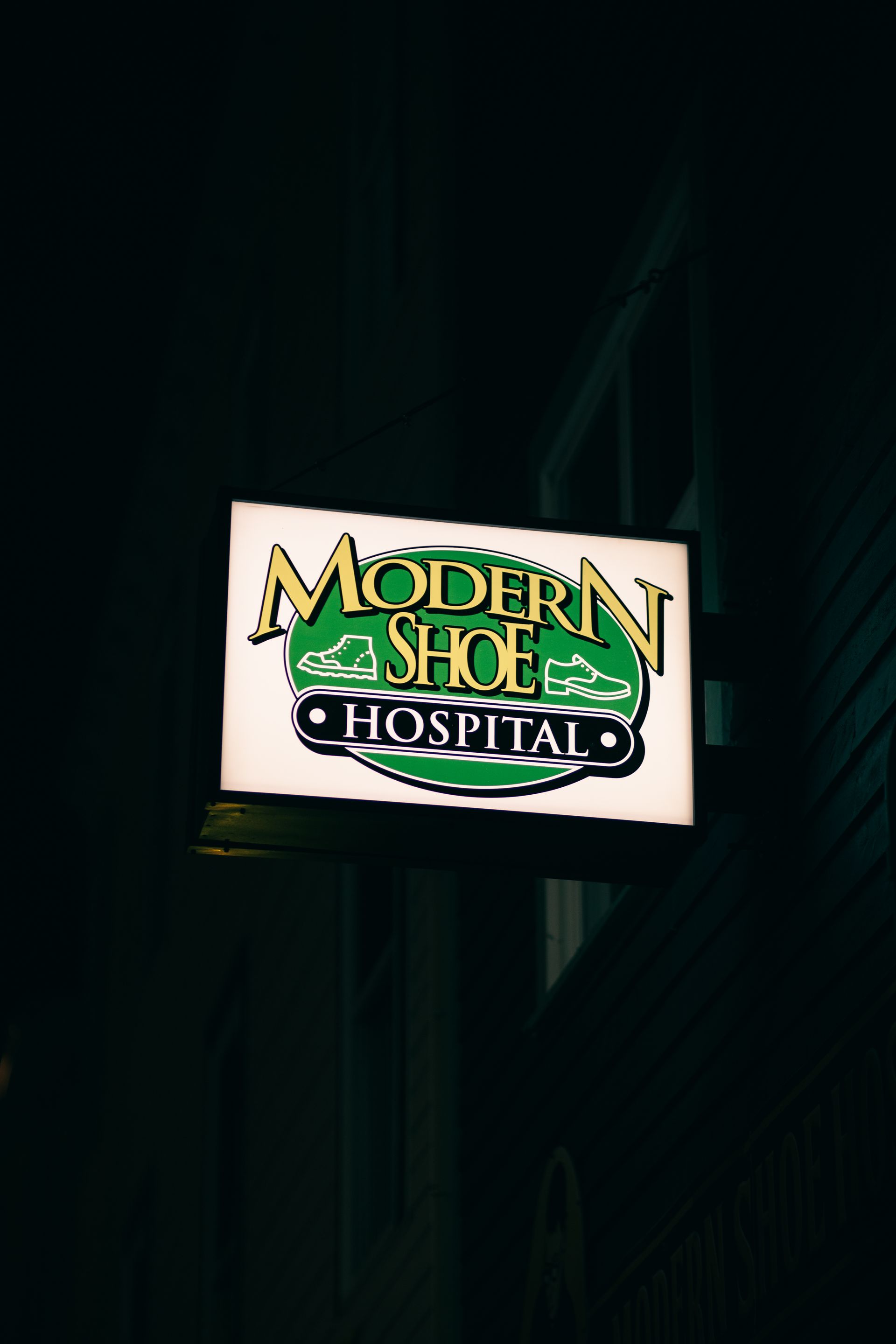 Lit storefront sign in an urban setting