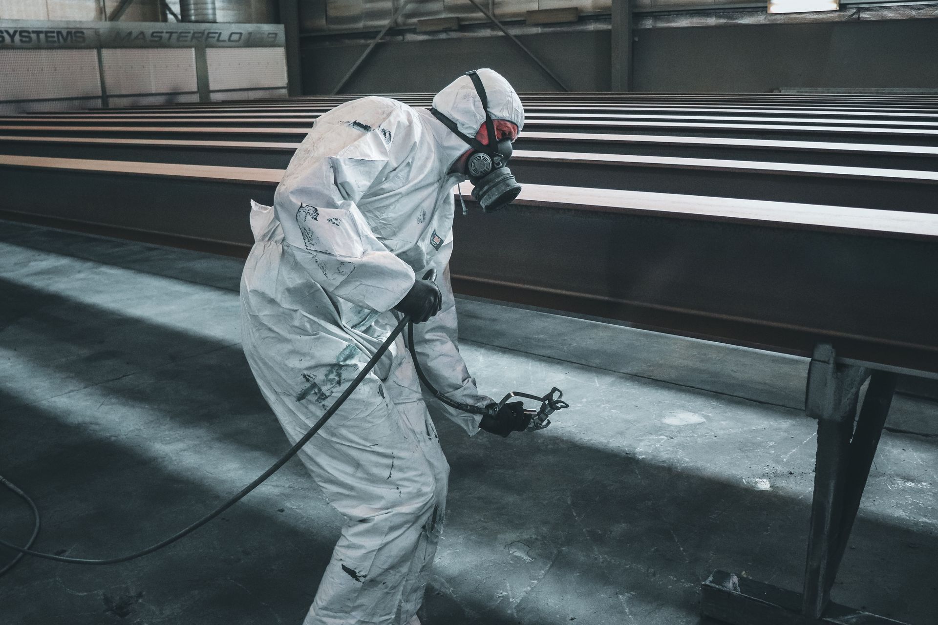 Worker spray painting metal parts