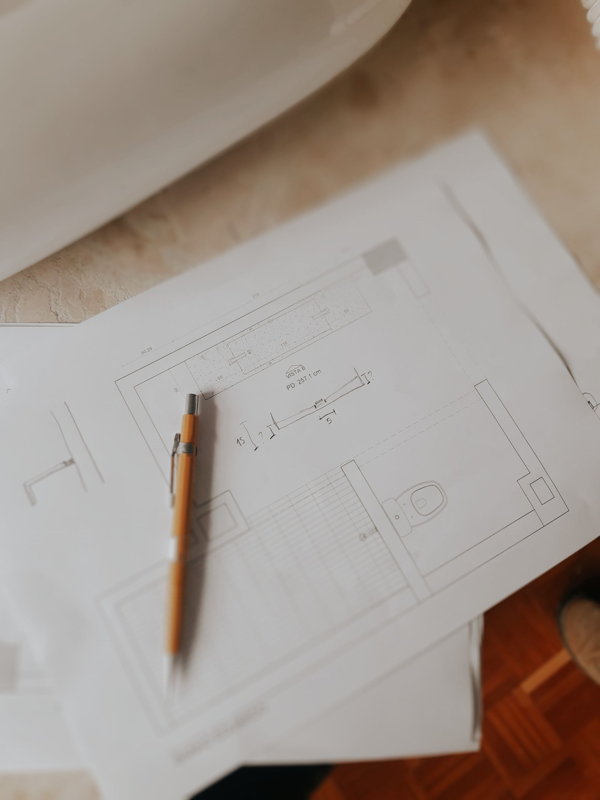 Floor plans and a pen on a desk