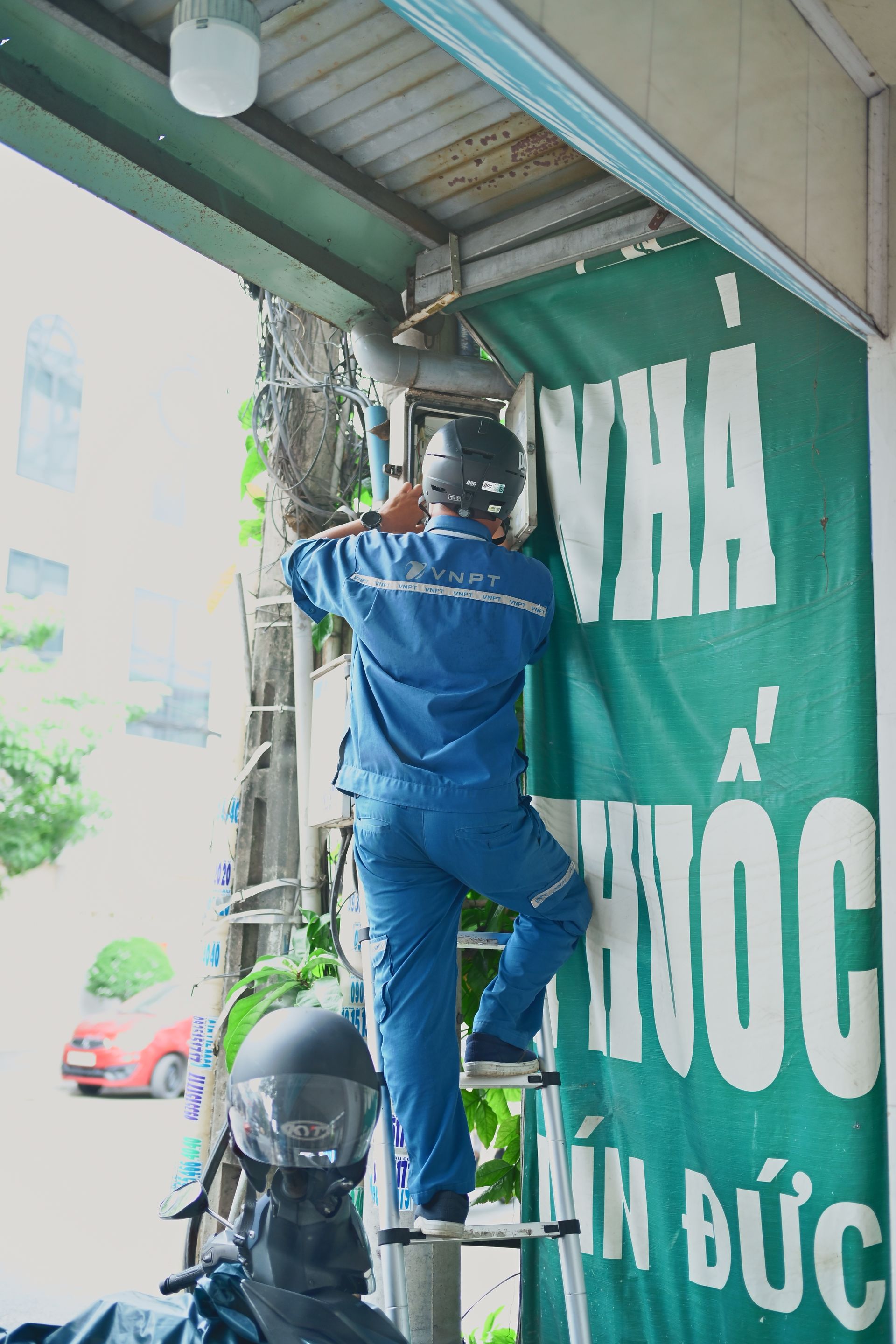 Technician installing equipment on a ladder