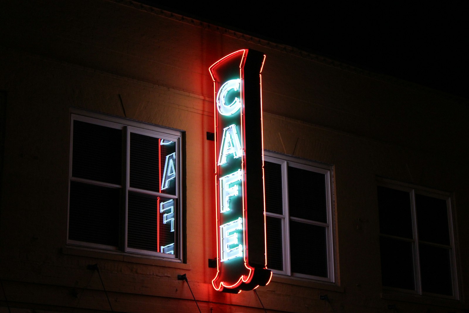 Red and blue neon cafe sign on a building